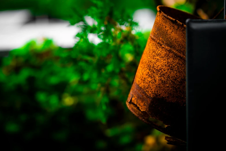 rusted and broken planter hanging off the side of a building