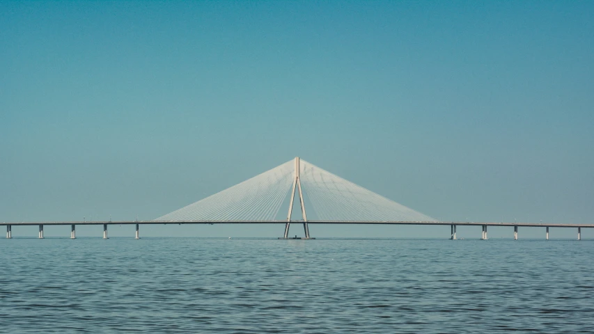 a large bridge across the ocean is seen