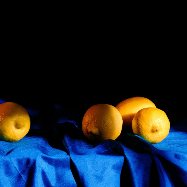 a blue cloth with four oranges on it