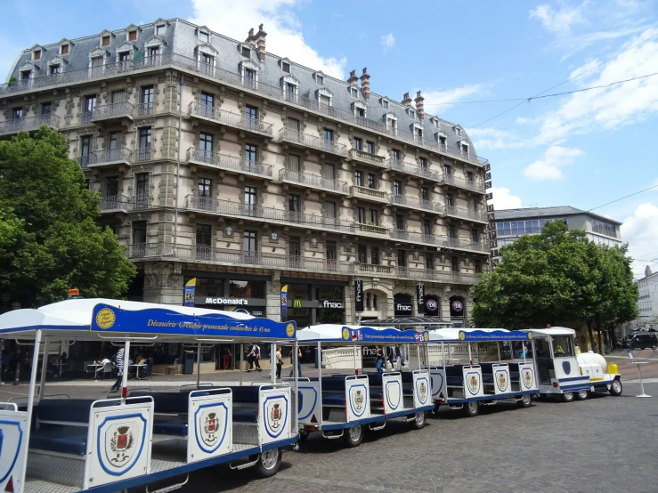 a line of street food carts in front of a large building