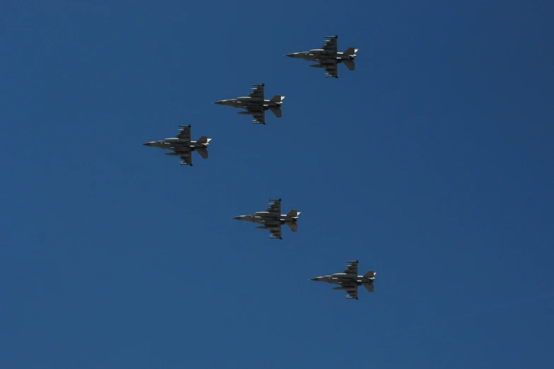 four planes flying in formation under a blue sky