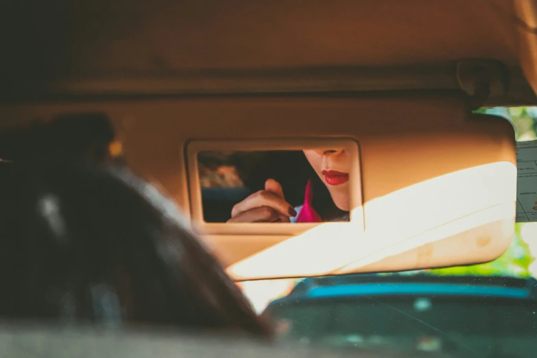 a woman is seen from the inside of a car