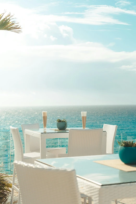 table and chairs by the beach with view of water
