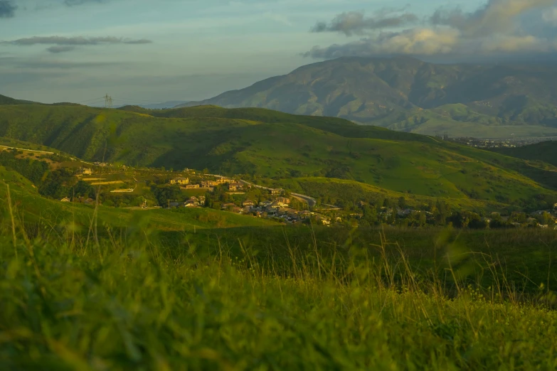 a landscape view of some green mountains and grass