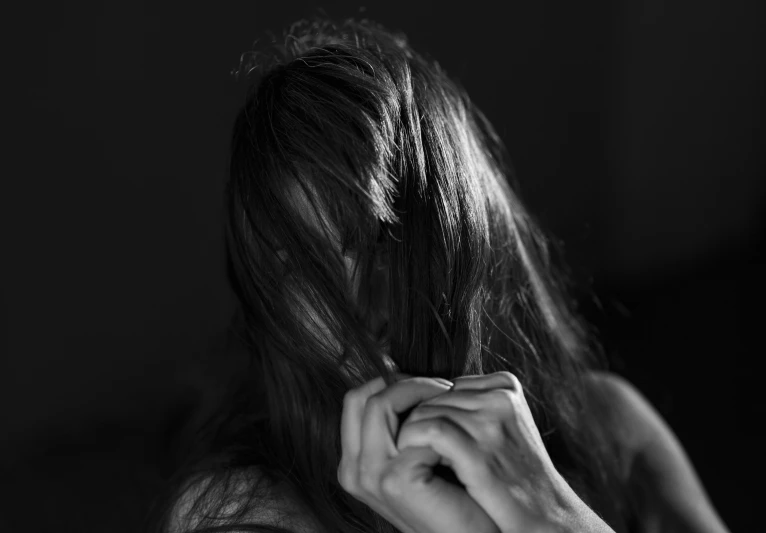 a woman is straightening her long, straight hair