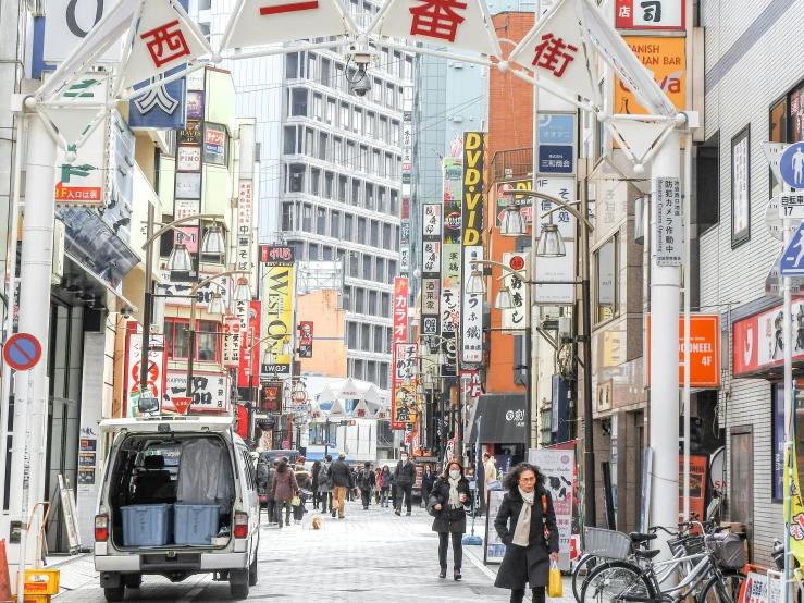 a city with pedestrians, cars and advertits