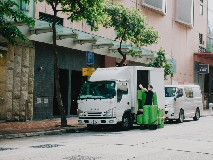 several white vans in front of a building on a city street