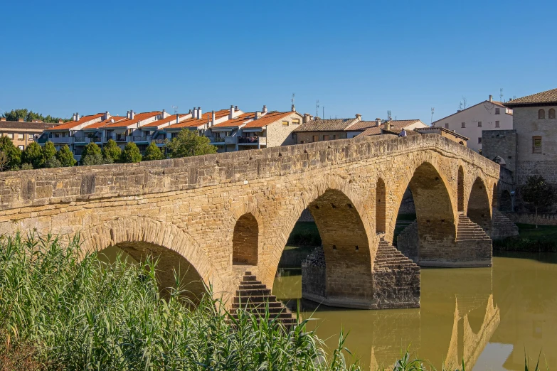 a bridge with stone arches above a small stream