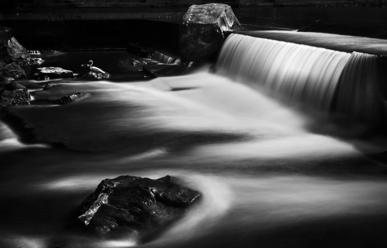 a waterfall flows with rocks underneath it