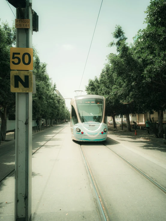 a small, light blue car travelling down a road