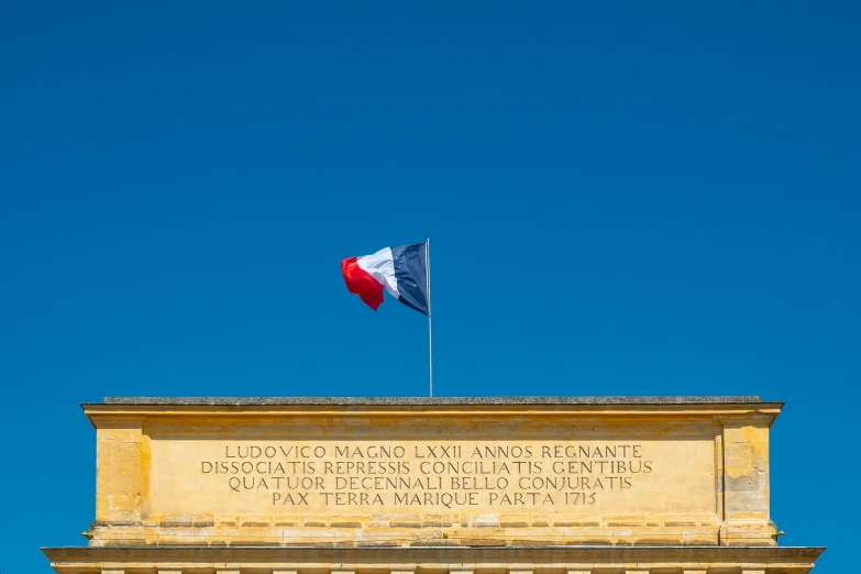 a french flag flies above the front of the united states capitol