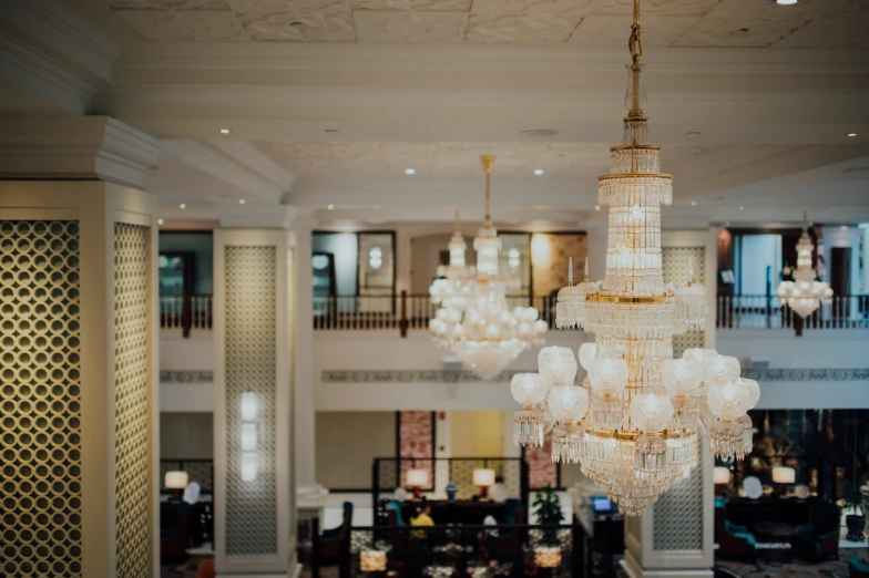 a very elegant chandelier and multiple lights in the middle of a lobby