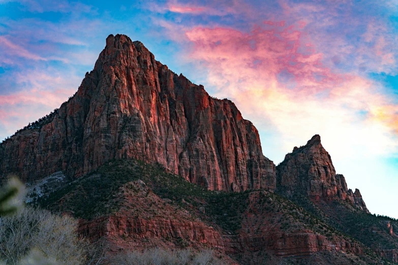 the top of a very tall mountain with a pink and yellow sky