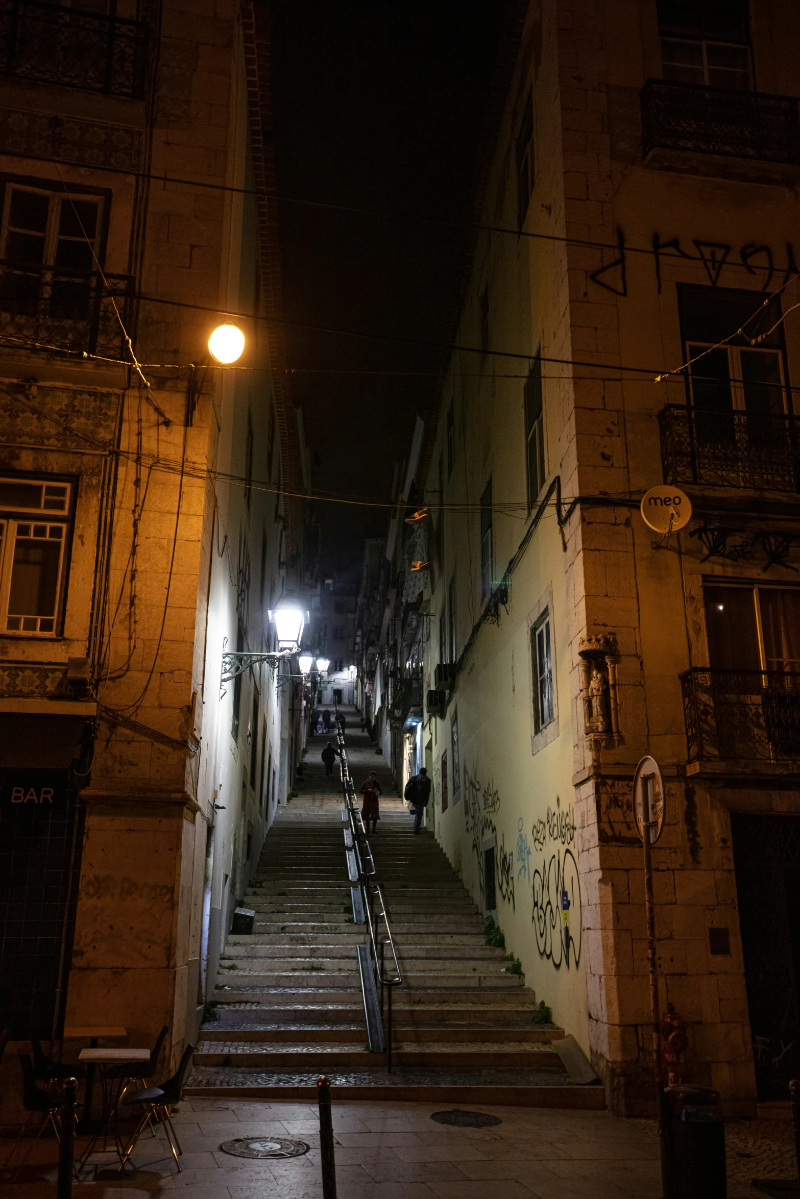 stairs in an alley leading up to buildings with graffiti on them