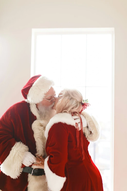 santa claus kissing a woman in the corner of the room