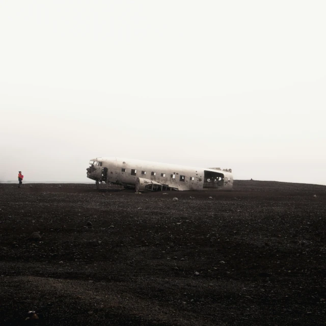 airplane in field with people on hill near cloudy sky