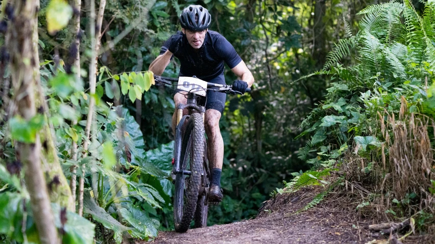 a person riding a mountain bike through the woods