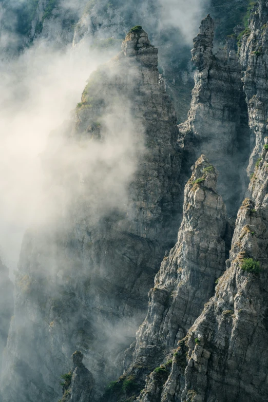 some big rocks and very low clouds around it