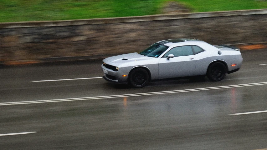 a sports car is racing down a rainy street