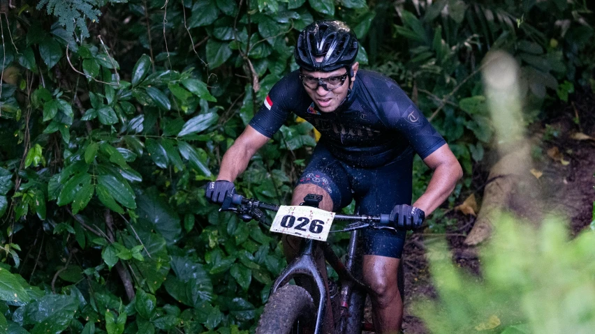 a man riding a bike through the forest