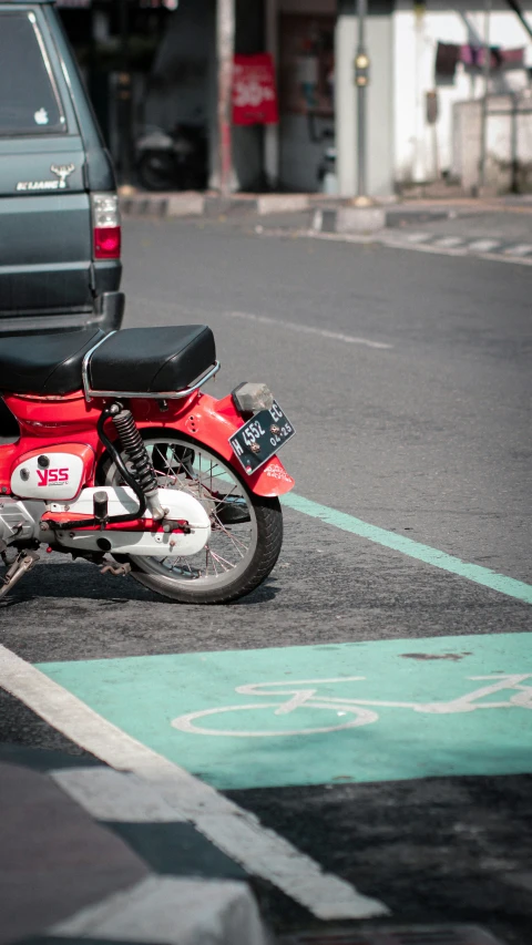 a red motorcycle parked by itself at a cross walk