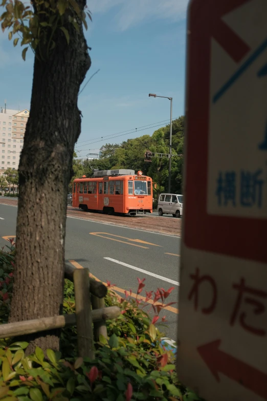 an orange trolley is going down the street