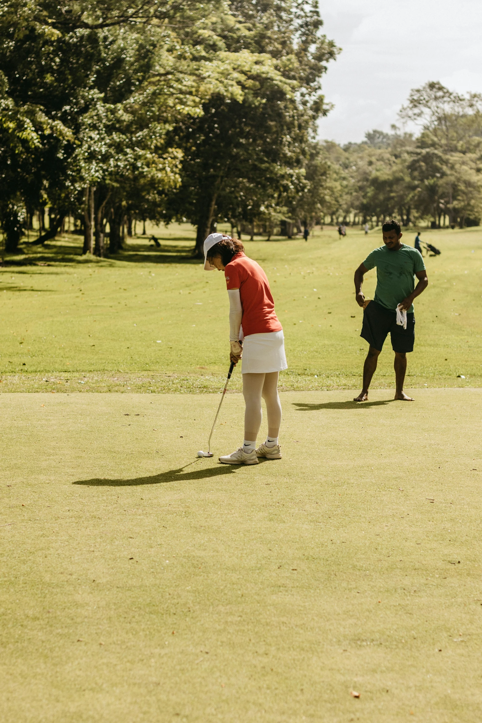 two people are playing golf in the grass