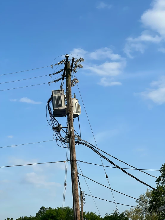 an electric utility pole with lots of wires and a phone