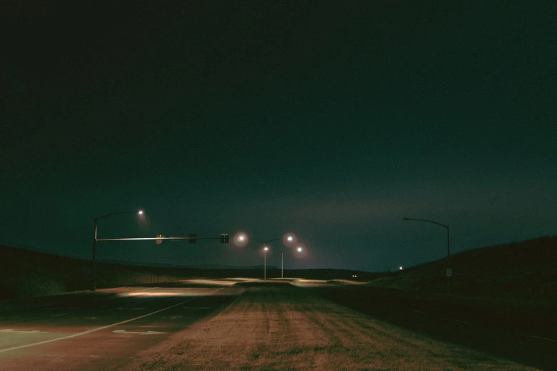 a road with some street lights shining in the night sky