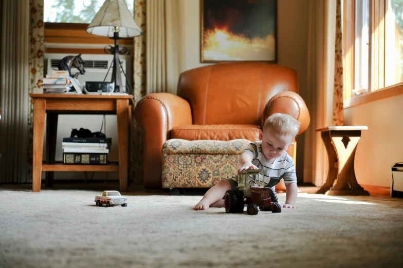 a child plays on the floor by a chair