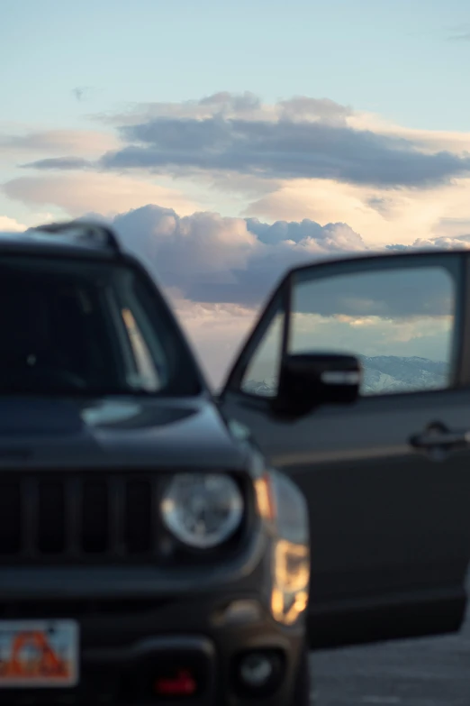 two cars sitting on a road near a body of water