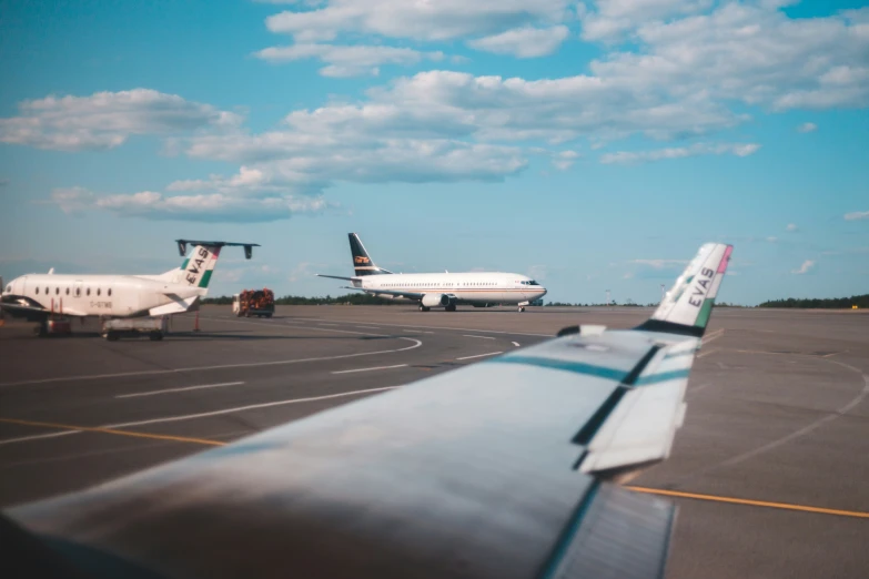 some planes sitting on the ground and some in front