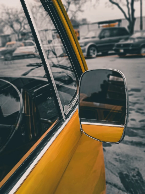 the side mirror on a yellow car parked next to it's doors