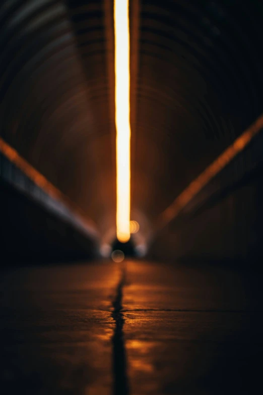 light shining in an orange tunnel near a brick wall