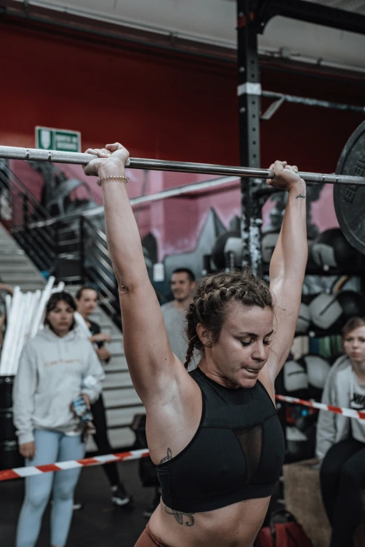a female athlete at a crossfit competition holding her hands up to the sides