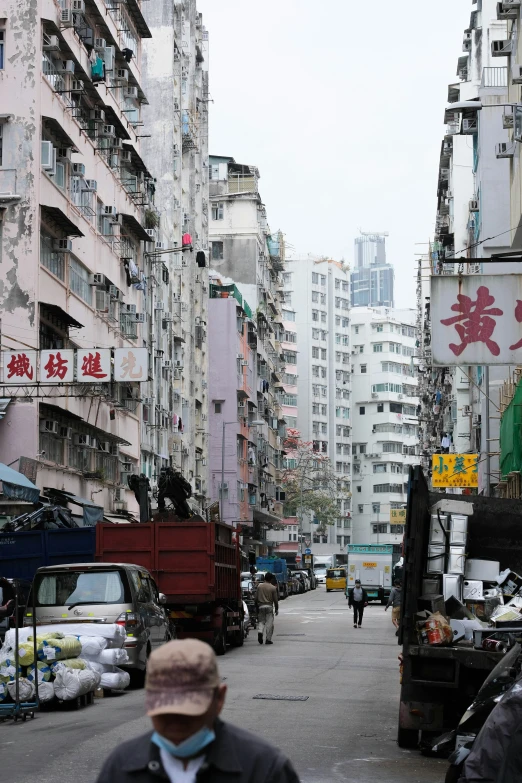 a view down a city street, of multiple tall buildings in an area that has not many people in it