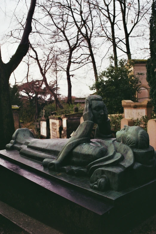 a small statue of a man in a graveyard