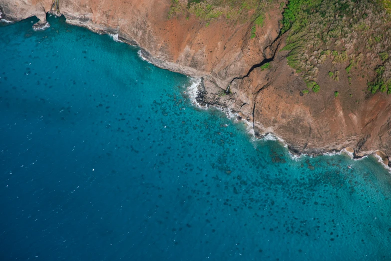 aerial view of some water with a sandy shore next to it