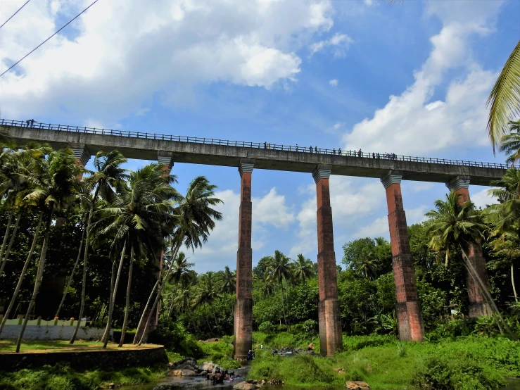 several tall, concrete structures on either side of river and trees