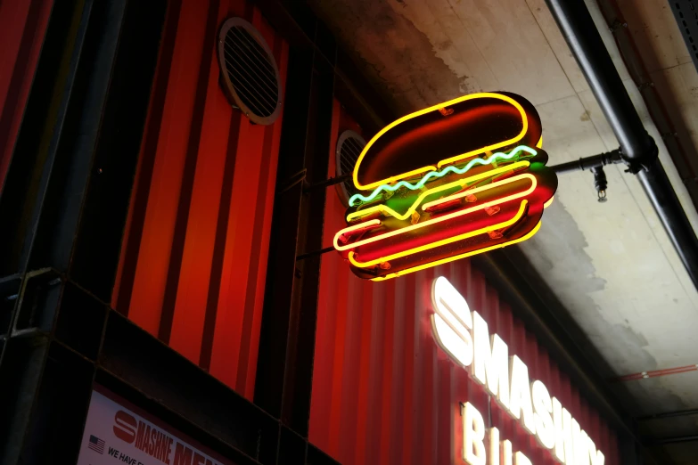 a neon sign hangs from the ceiling on the outside of a building