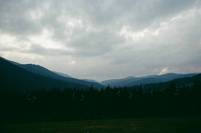 a mountain range at twilight time under a cloudy sky