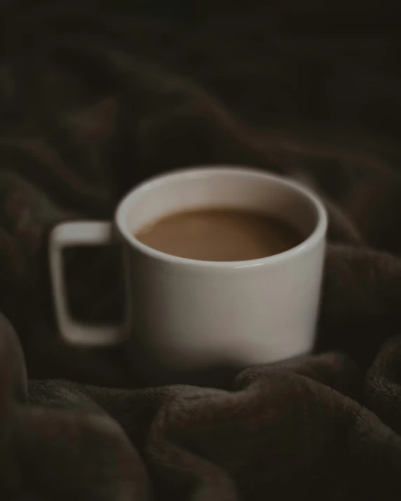 a cup of coffee that is on a blanket