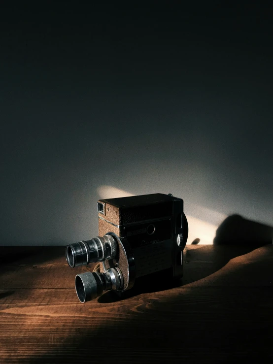 an old camera and its light on a wooden table