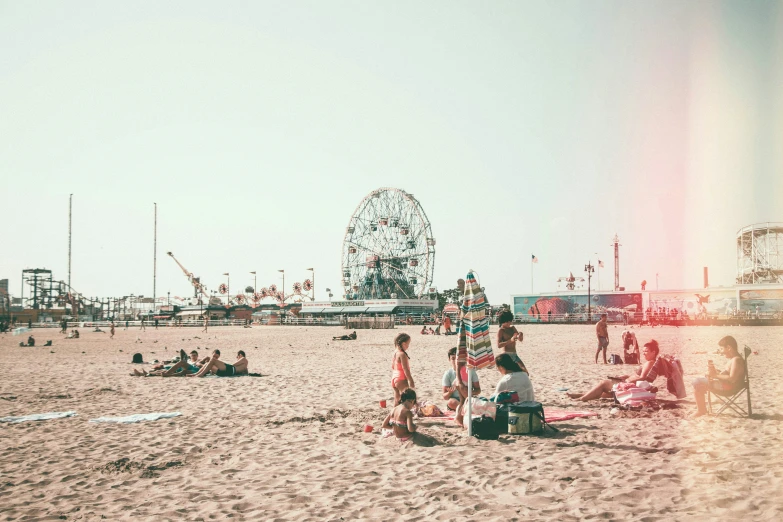 people sitting and standing on a sandy beach