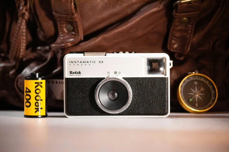 an old camera next to a pocket sized battery and clock