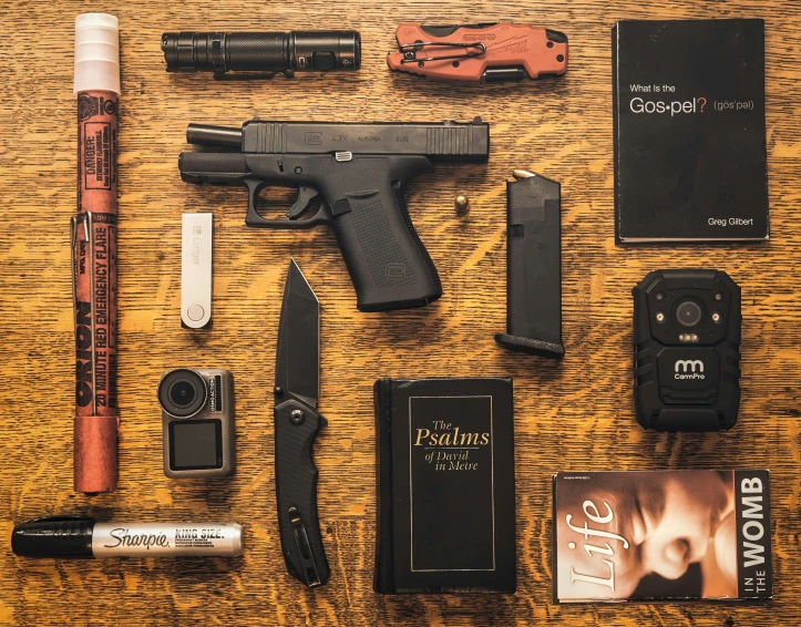 a gun, lighter and several other items laid out on a table