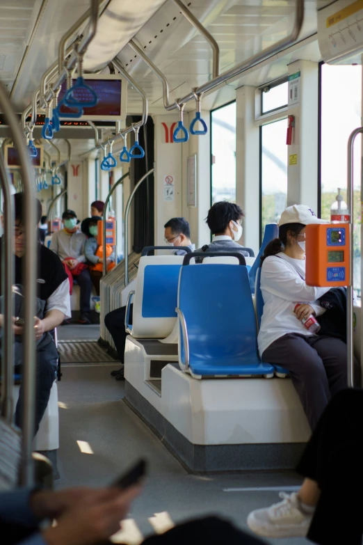 people sitting on a bus looking at their phones