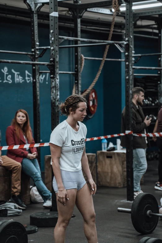 a woman standing next to a barbell weight