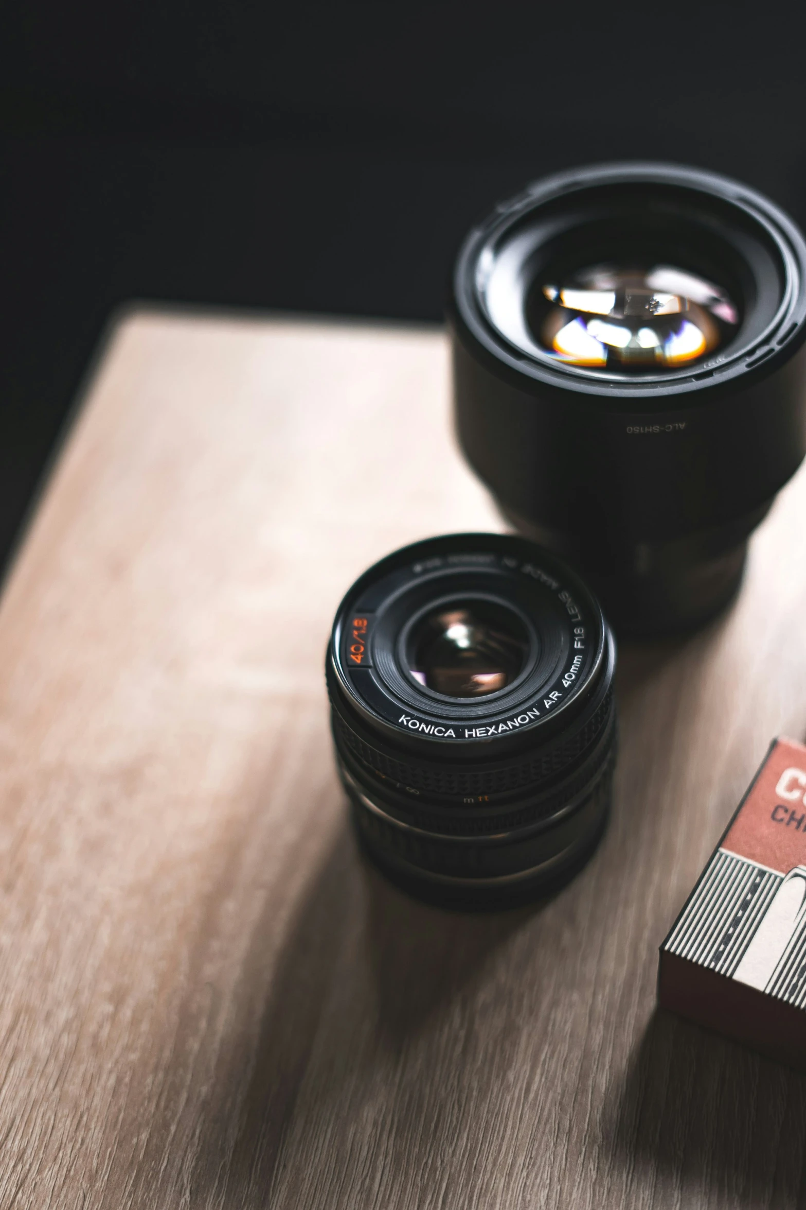 two black cameras on top of a wooden table