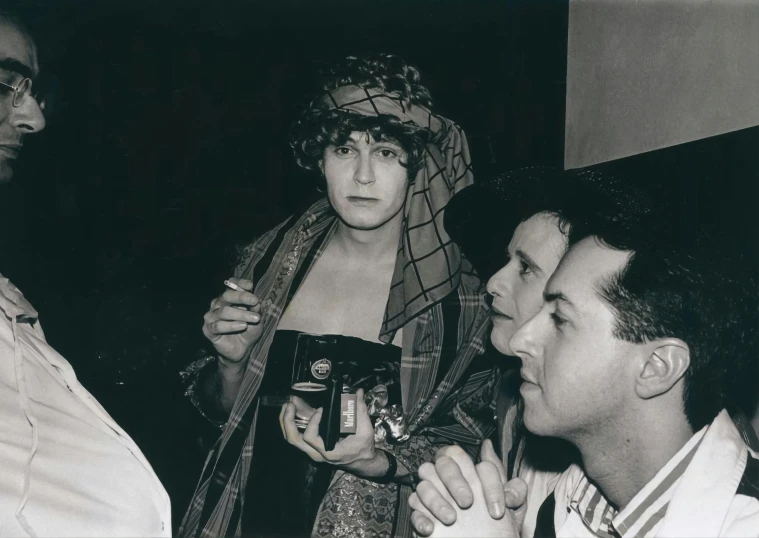 three men are holding drinks at a party